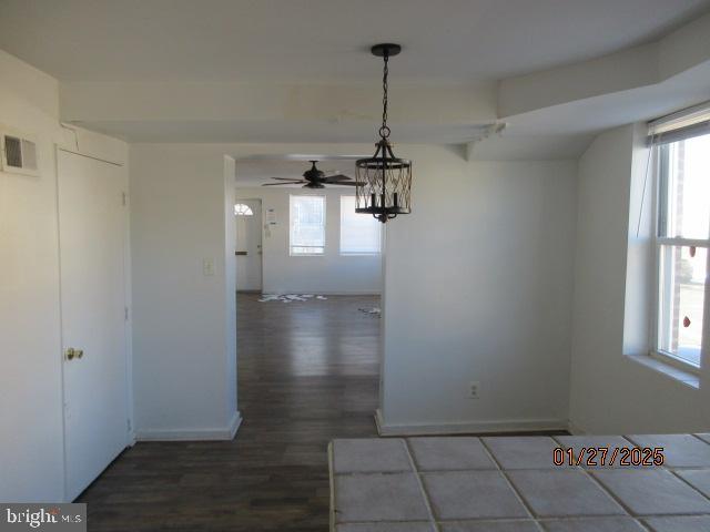 unfurnished dining area featuring dark hardwood / wood-style floors and a chandelier