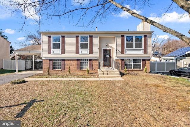 raised ranch with a front yard and a carport