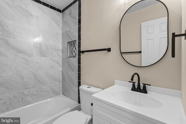 full bathroom featuring tiled shower / bath, vanity, and toilet