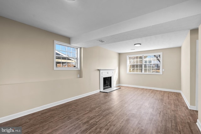 unfurnished living room featuring wood-type flooring and a healthy amount of sunlight