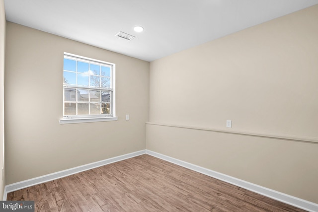 spare room featuring wood-type flooring