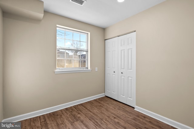 unfurnished bedroom with wood-type flooring and a closet