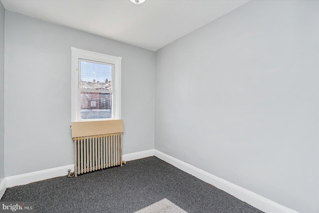 empty room with carpet floors and radiator heating unit