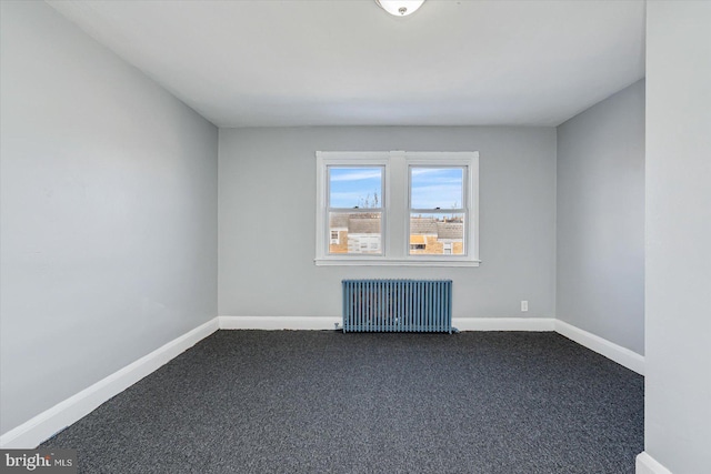 unfurnished room with dark colored carpet and radiator