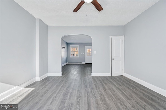 spare room featuring hardwood / wood-style flooring, ceiling fan, a baseboard heating unit, and a textured ceiling