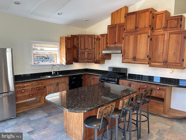 kitchen featuring a kitchen island, sink, dark stone countertops, a kitchen bar, and black appliances