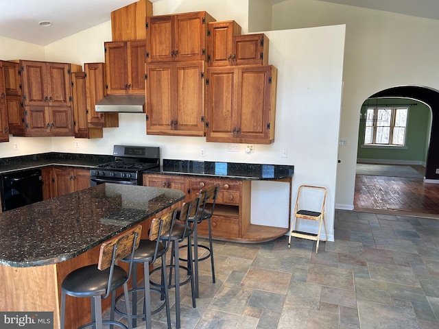 kitchen with lofted ceiling, range with gas stovetop, dark stone counters, and black dishwasher