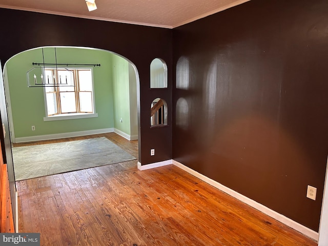 entrance foyer with crown molding and wood-type flooring