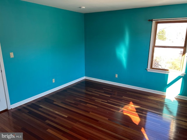 empty room with dark hardwood / wood-style flooring