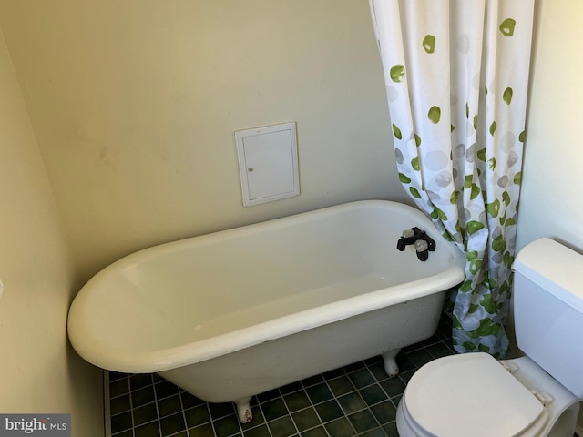 bathroom with tile patterned flooring, a bathing tub, and toilet