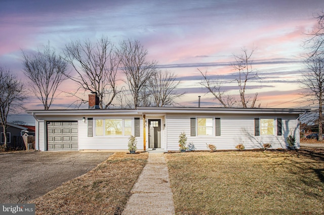 ranch-style house with a yard and a garage