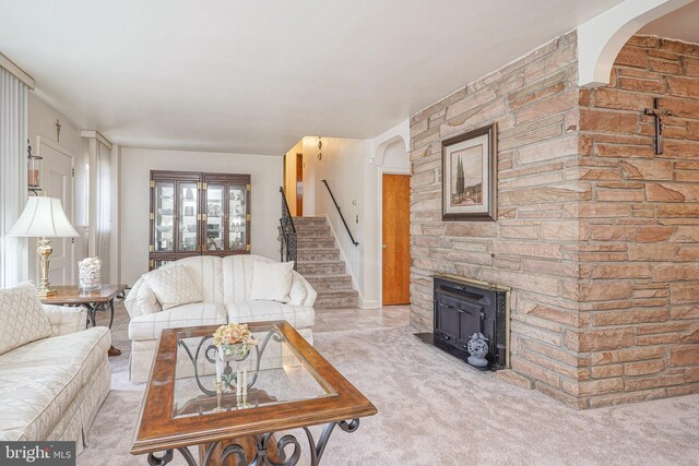 carpeted living area featuring stairs, arched walkways, and tile patterned flooring