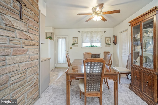 dining room with light carpet and a ceiling fan