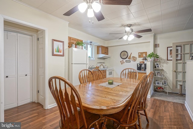 dining area with a ceiling fan, crown molding, baseboards, and wood finished floors