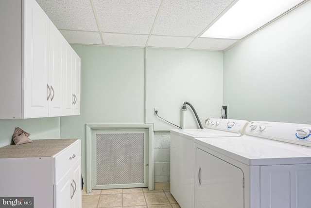 laundry room featuring light tile patterned floors, cabinet space, and washer and dryer