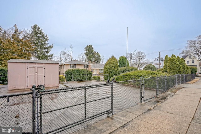 view of road with a residential view, sidewalks, and a gate