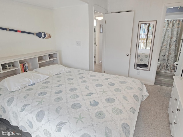 bedroom with light colored carpet and ensuite bathroom