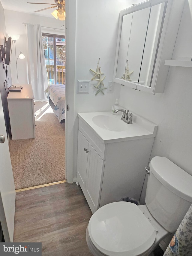 bathroom featuring hardwood / wood-style flooring, vanity, ceiling fan, and toilet