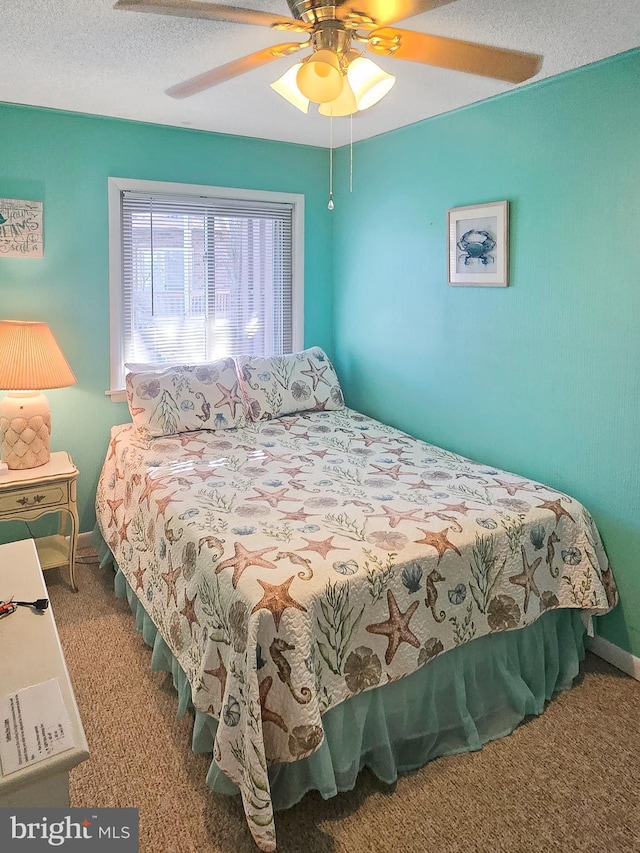 bedroom featuring ceiling fan, carpet flooring, and a textured ceiling