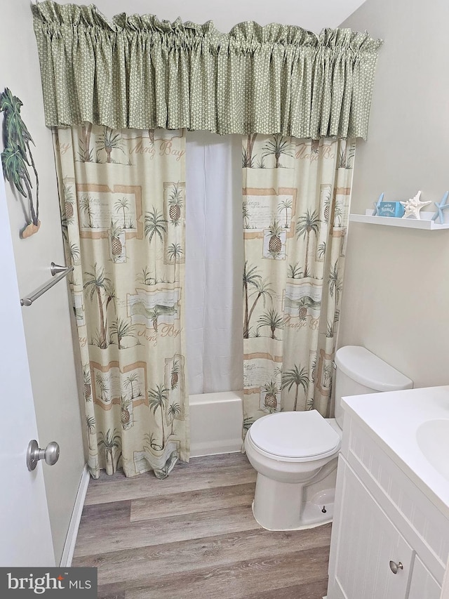 full bathroom featuring hardwood / wood-style flooring, vanity, shower / tub combo, and toilet