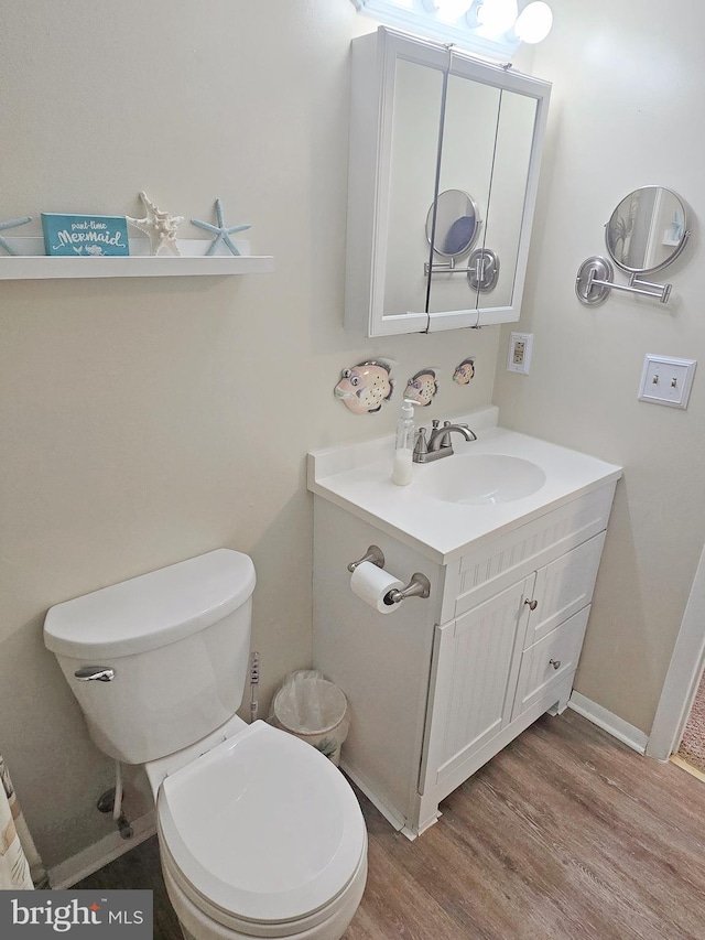 bathroom featuring vanity, hardwood / wood-style floors, and toilet