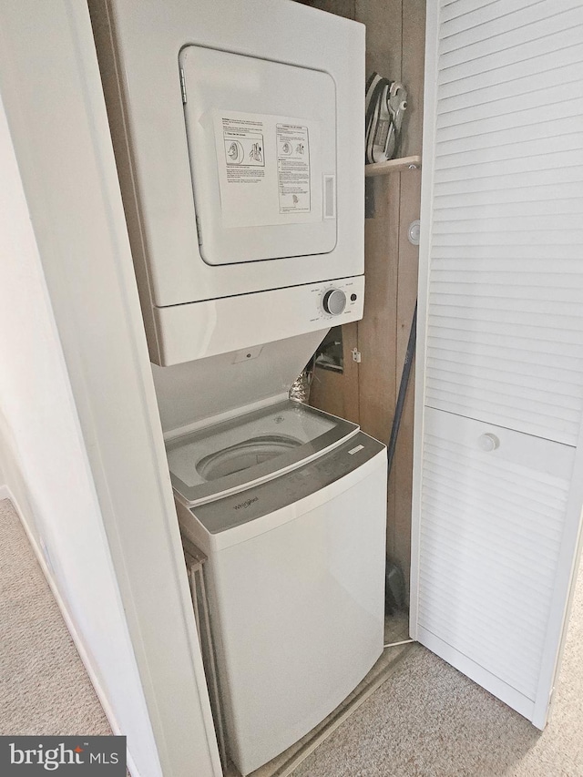 washroom featuring stacked washer and clothes dryer