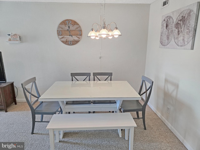 carpeted dining space featuring a chandelier