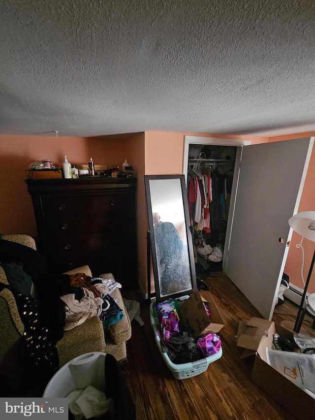 bedroom featuring dark wood-type flooring, a closet, and a textured ceiling