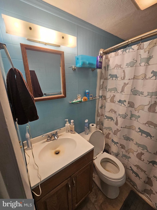 bathroom with vanity, toilet, curtained shower, and a textured ceiling