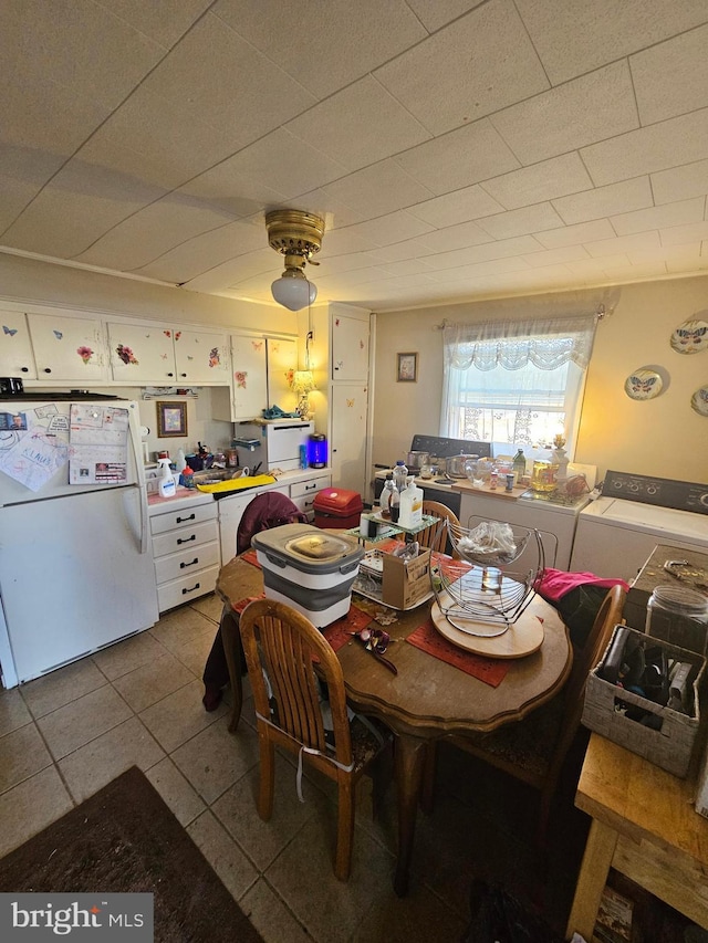 tiled dining room featuring independent washer and dryer