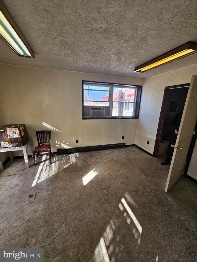 basement with dark colored carpet, cooling unit, and a textured ceiling