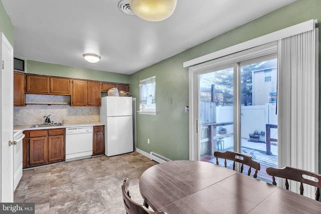 kitchen with tasteful backsplash, sink, white appliances, and baseboard heating