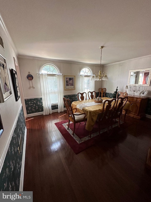 dining area featuring crown molding, dark hardwood / wood-style flooring, and a chandelier