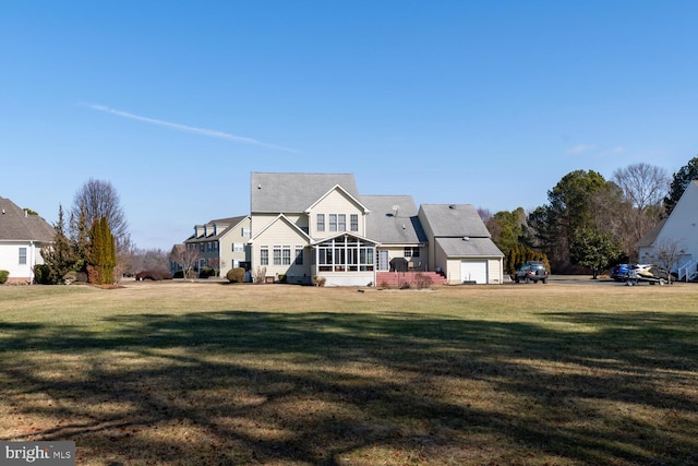 back of property with a sunroom and a lawn