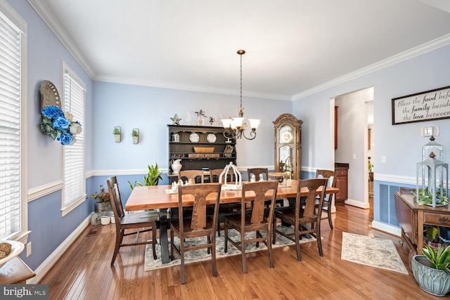 dining room with crown molding, a chandelier, and hardwood / wood-style floors