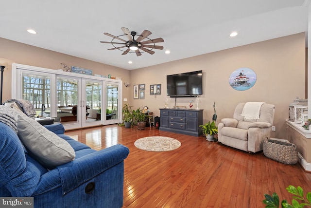 living room featuring hardwood / wood-style flooring, ceiling fan, and french doors