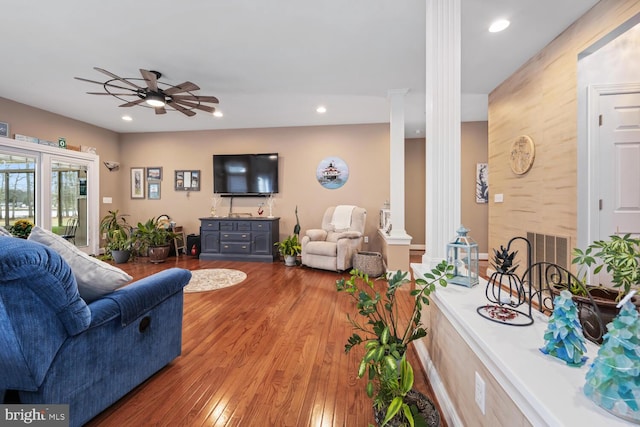 living room with ceiling fan, decorative columns, and light wood-type flooring