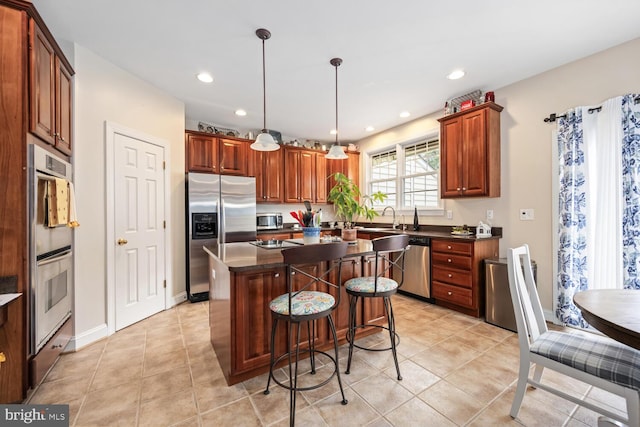 kitchen featuring light tile patterned flooring, sink, a center island, pendant lighting, and stainless steel appliances