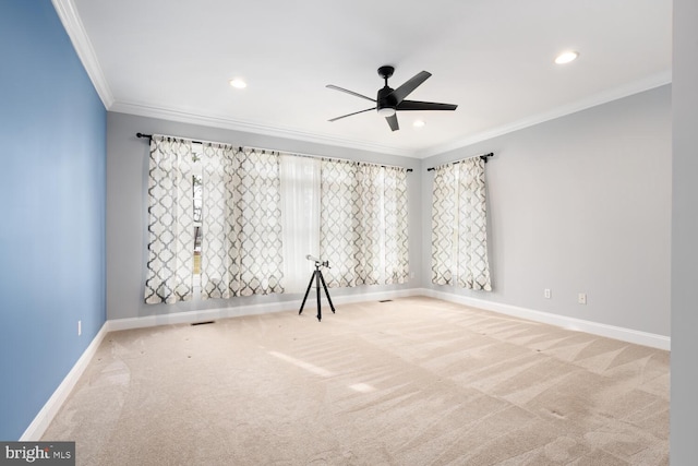 spare room with light carpet, crown molding, and ceiling fan