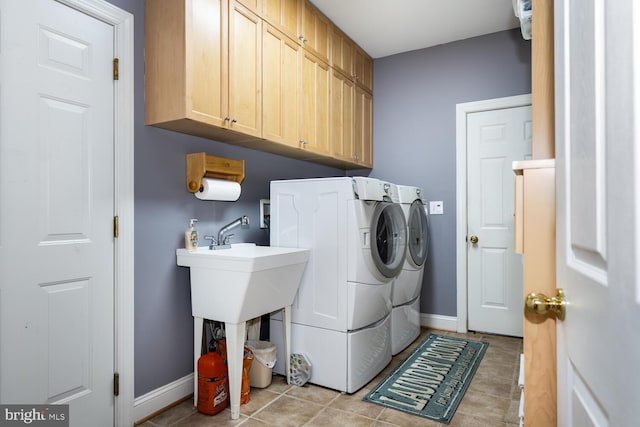 laundry area with cabinets, light tile patterned floors, and washing machine and clothes dryer