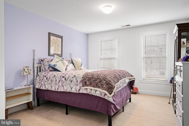 bedroom featuring multiple windows and light carpet