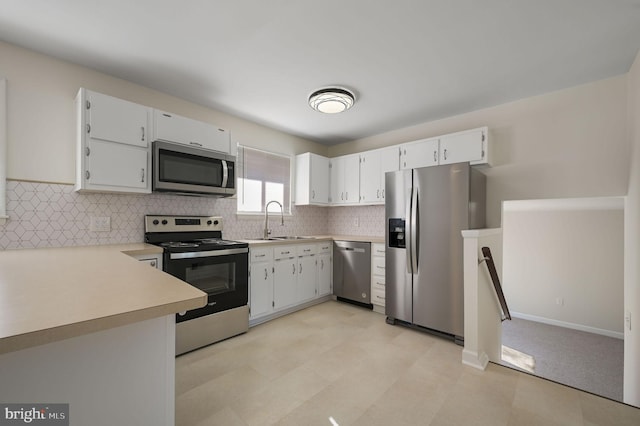 kitchen with white cabinetry, sink, decorative backsplash, and stainless steel appliances