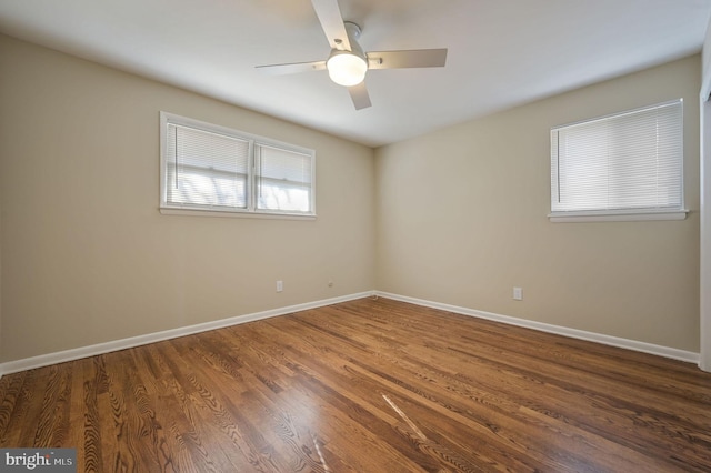 empty room with dark hardwood / wood-style floors and ceiling fan