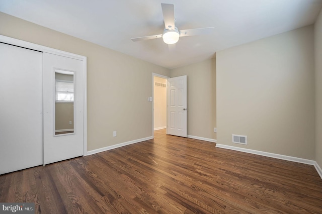 unfurnished bedroom with ceiling fan, dark hardwood / wood-style flooring, and a closet