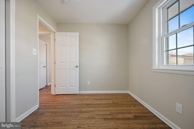 unfurnished bedroom with dark wood-type flooring