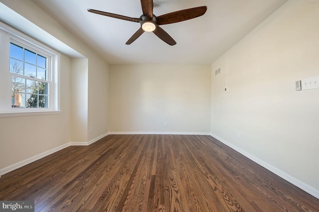 spare room with dark wood-type flooring and ceiling fan