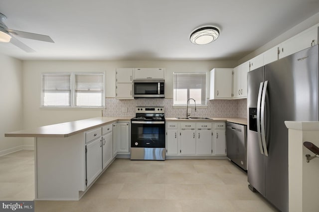 kitchen with white cabinetry, stainless steel appliances, sink, and tasteful backsplash