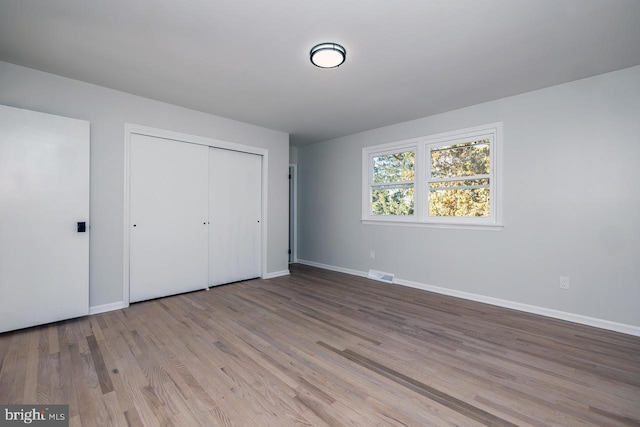 unfurnished bedroom featuring a closet and light wood-type flooring