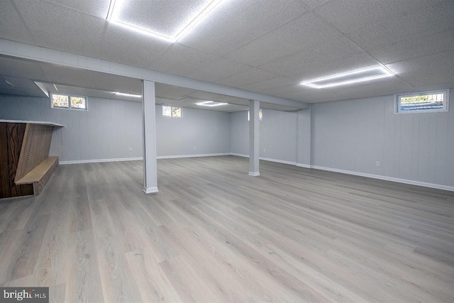 basement with hardwood / wood-style flooring and a drop ceiling