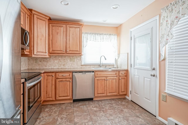 kitchen with stainless steel appliances, a baseboard radiator, sink, and backsplash